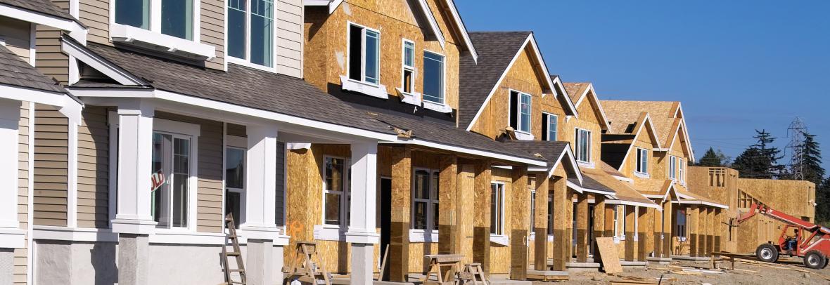 Housing Development Under Construction - stock photo  Perspective photo of a row of similar style houses during various phases of construction.