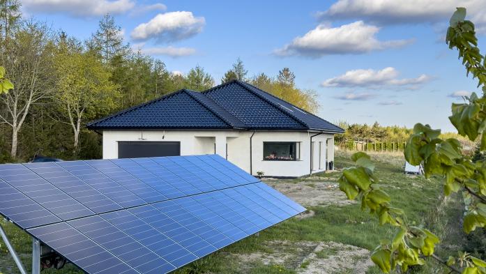 New house under construction with solar panels in the yard. Eco power source green energy concept.