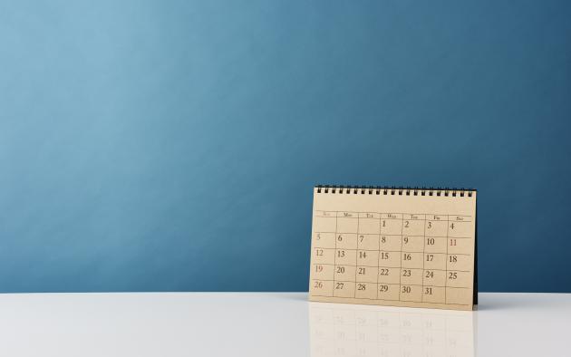 paper calendar standing upright against blue background